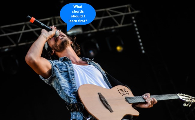 image of man playing guitar live screaming into microphone "What chords should I learn first?"